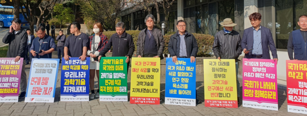 지난 24일 국회 과방위 국정감사가 열린 한국전자통신연구원 연구동 앞에서 과기 연대회의 구성원들이 팻말을 들고 시위 중이다.                                                                                                                                이어확 과기 연대회의 공동대표 제공